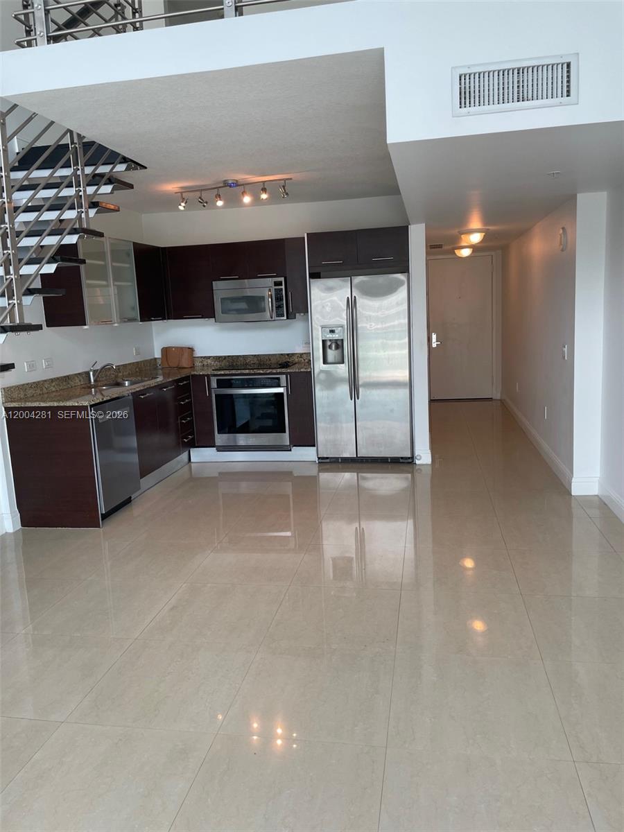 41 Southeast 5th Street, Unit 1614 Miami, FL 33131 - Photo 7 of 23 a view of a room with stainless steel appliances wooden floor and living room view