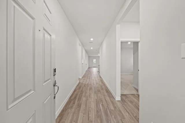 a view of a hallway with wooden floor and staircase