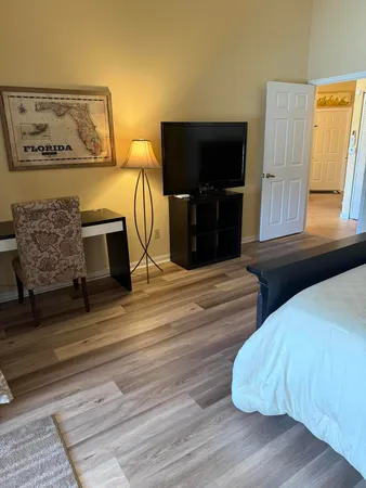a living room with a bed furniture and a flat screen tv
