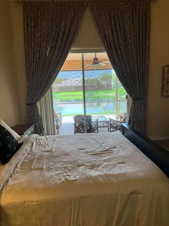 a bed sitting in a bedroom next to a larger window
