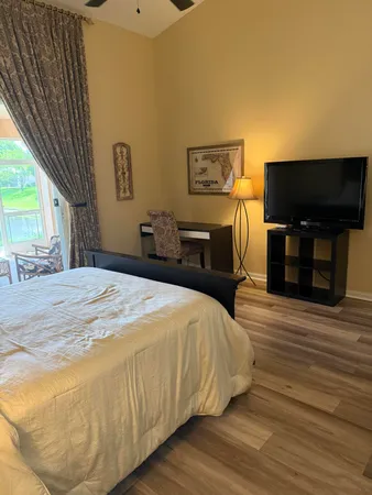 a bedroom with a bed and wooden floor