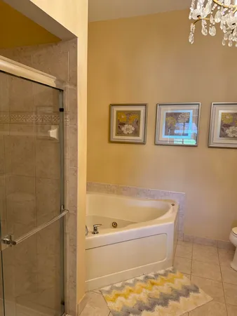 a bath tub sitting next to a white toilet and a shower