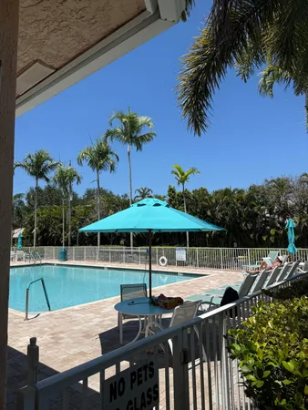 an outdoor sitting area with furniture and umbrella