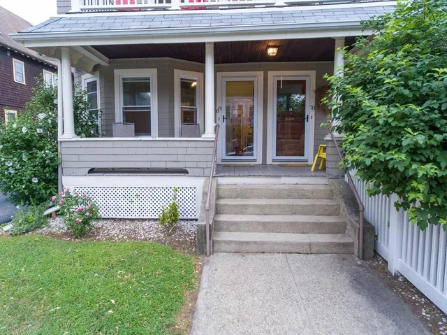 a view of a house with potted plants and a bench