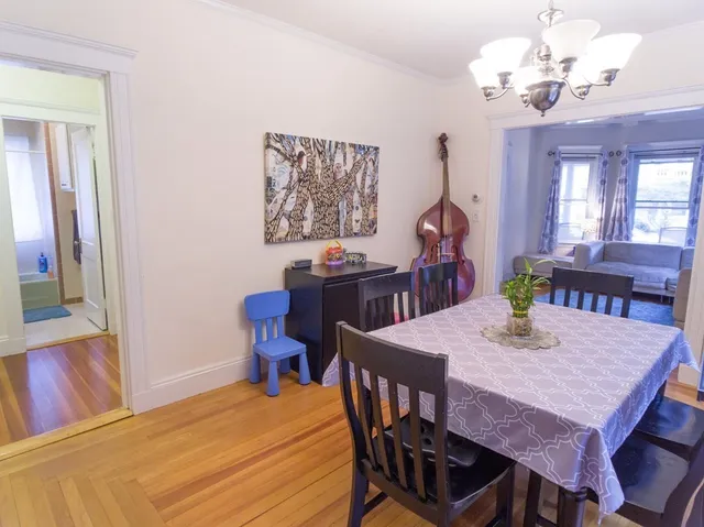 a view of a dining room with furniture a chandelier and wooden floor