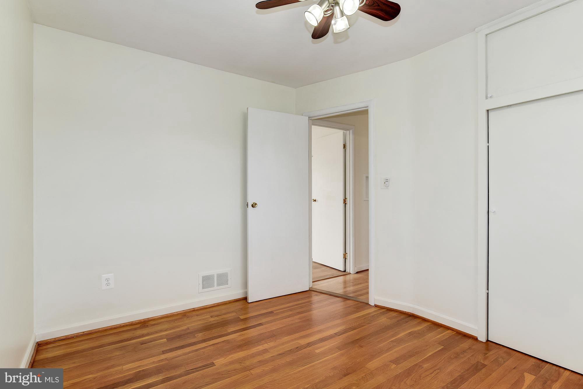 12611 Bluhill Road Silver Spring, MD 20906 - Photo 22 of 30 an empty room with wooden floor fan and windows