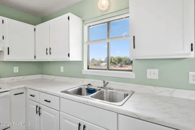 a kitchen with a sink cabinets and window
