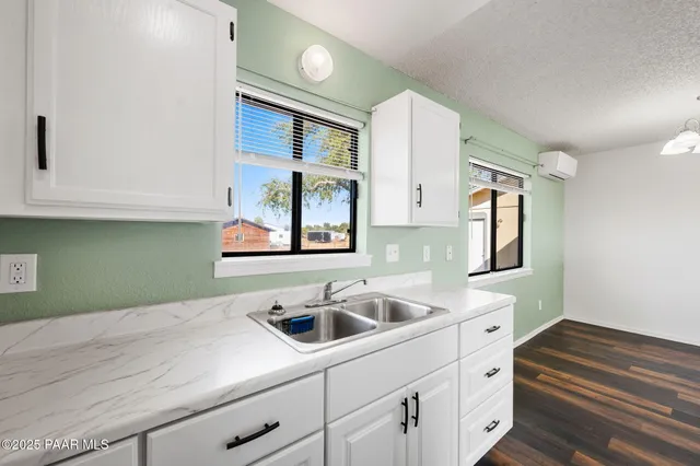 a kitchen with a sink cabinets and a wooden floor