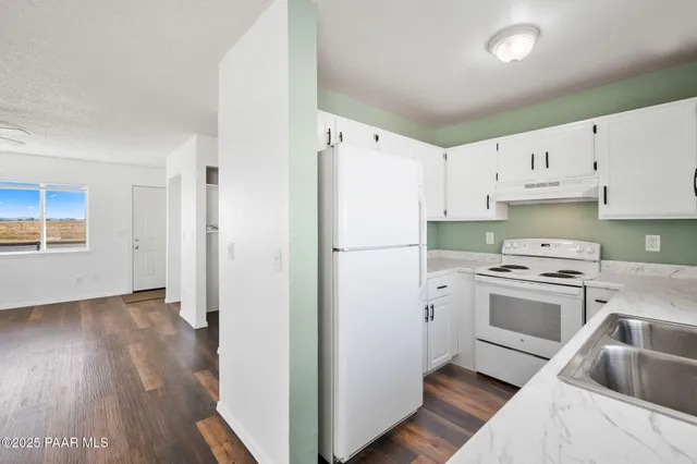 a kitchen with a refrigerator sink and cabinets
