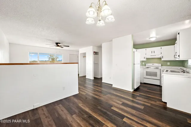 a view of a dining room with furniture a chandelier and wooden floor