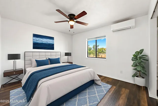 an empty room with wooden floor ceiling fan and windows