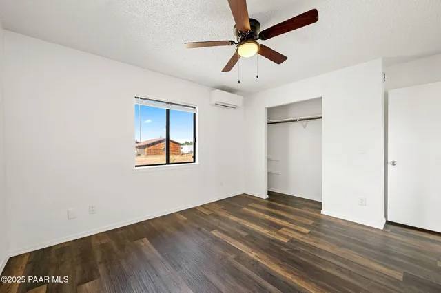 a bedroom with a large bed a chandelier and dresser
