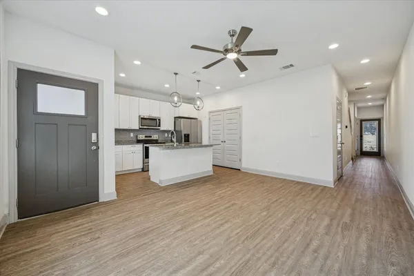 a view of a kitchen with wooden floor a sink and dishwasher