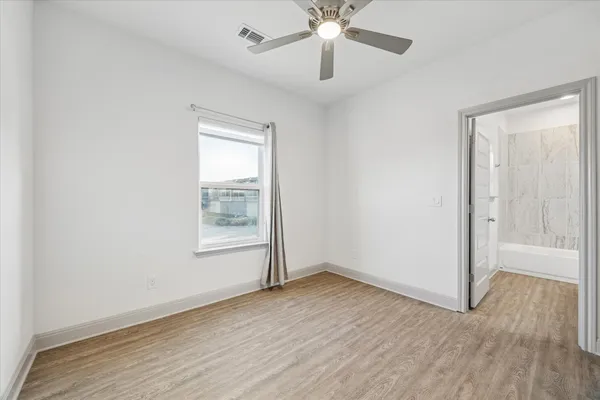 an empty room with closet and windows