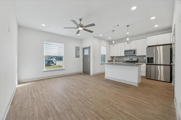 a large kitchen with cabinets wooden floor and stainless steel appliances