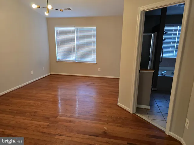 an empty room with wooden floor and closet