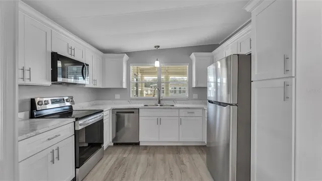 a kitchen with stainless steel appliances a refrigerator sink and microwave