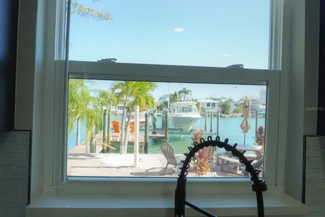 a view of a room with a large window and wooden floor