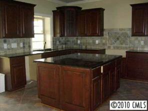 2718 Old Course Road Monroe, NC 28112 - Photo 4 of 8 a kitchen with granite countertop a sink and a black cabinets