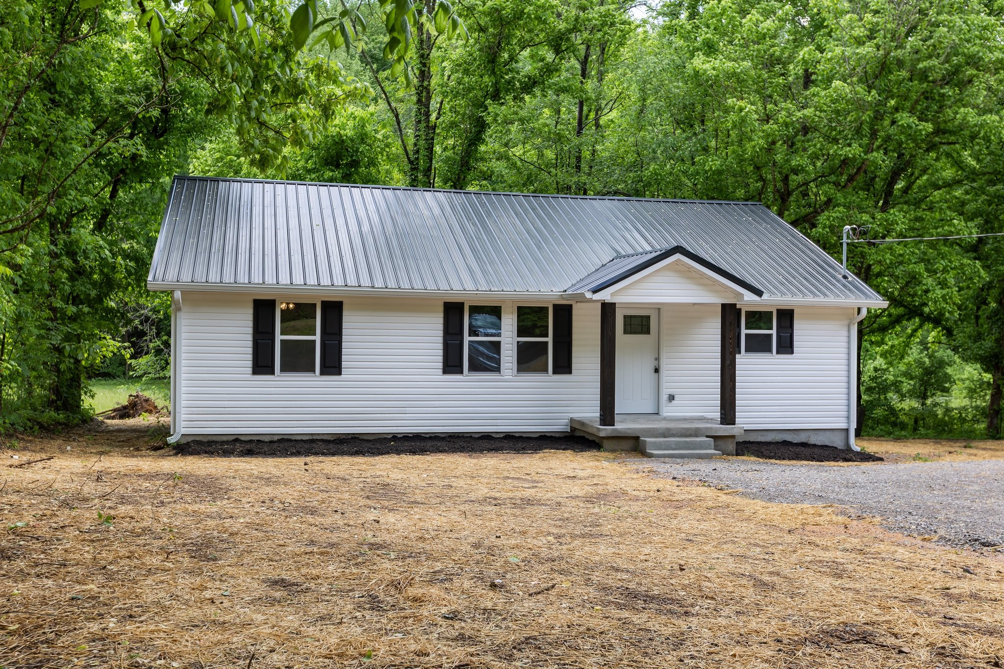 1591 Marsh Creek Road Linden, TN 37096 - Photo 1 of 30 a front view of a house with a garden