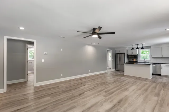 a view of a kitchen with wooden floor and a ceiling fan