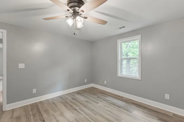 wooden floor in an empty room with a window