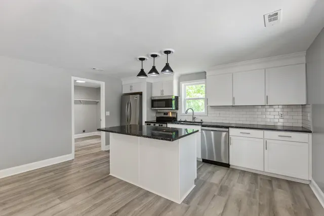 a kitchen with granite countertop a stove and a sink