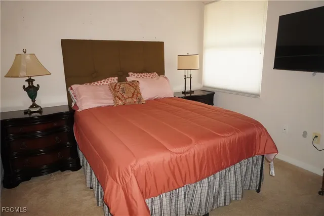 a bedroom with a bed and a flat tv screen on the dresser