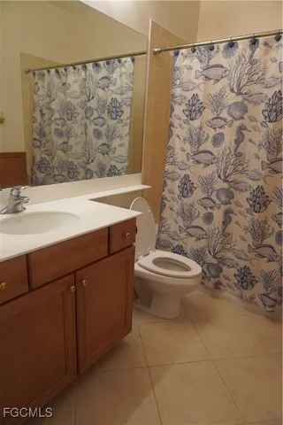 a bathroom with a sink a toilet and shower curtain