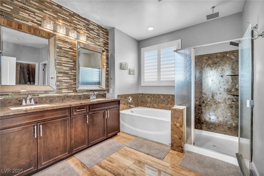 952 McKinley View Avenue Henderson, NV 89012 - Photo 7 of 82 Bathroom with backsplash, a garden tub, a shower stall, and double vanity
