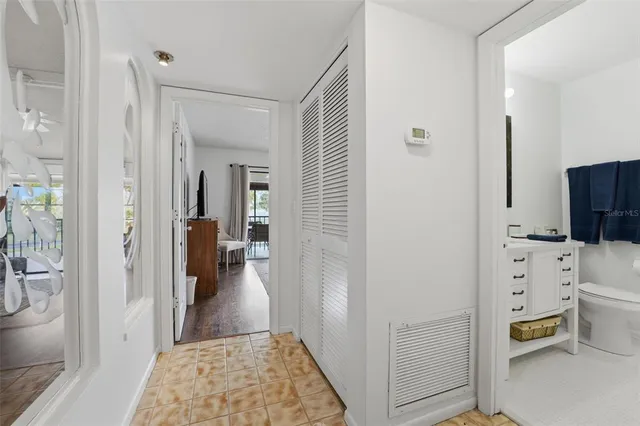 a view of a hallway with bathroom and wooden floor