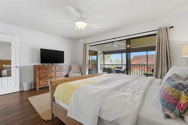 a bedroom with a bed and a flat tv screen on dresser