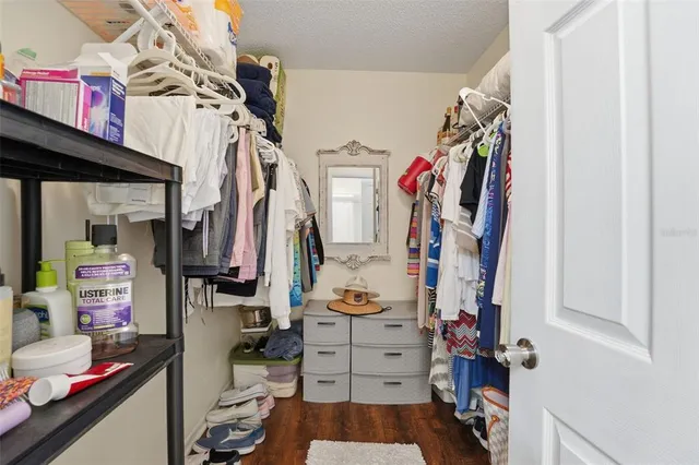a view of walk in closet with clothes and shoes