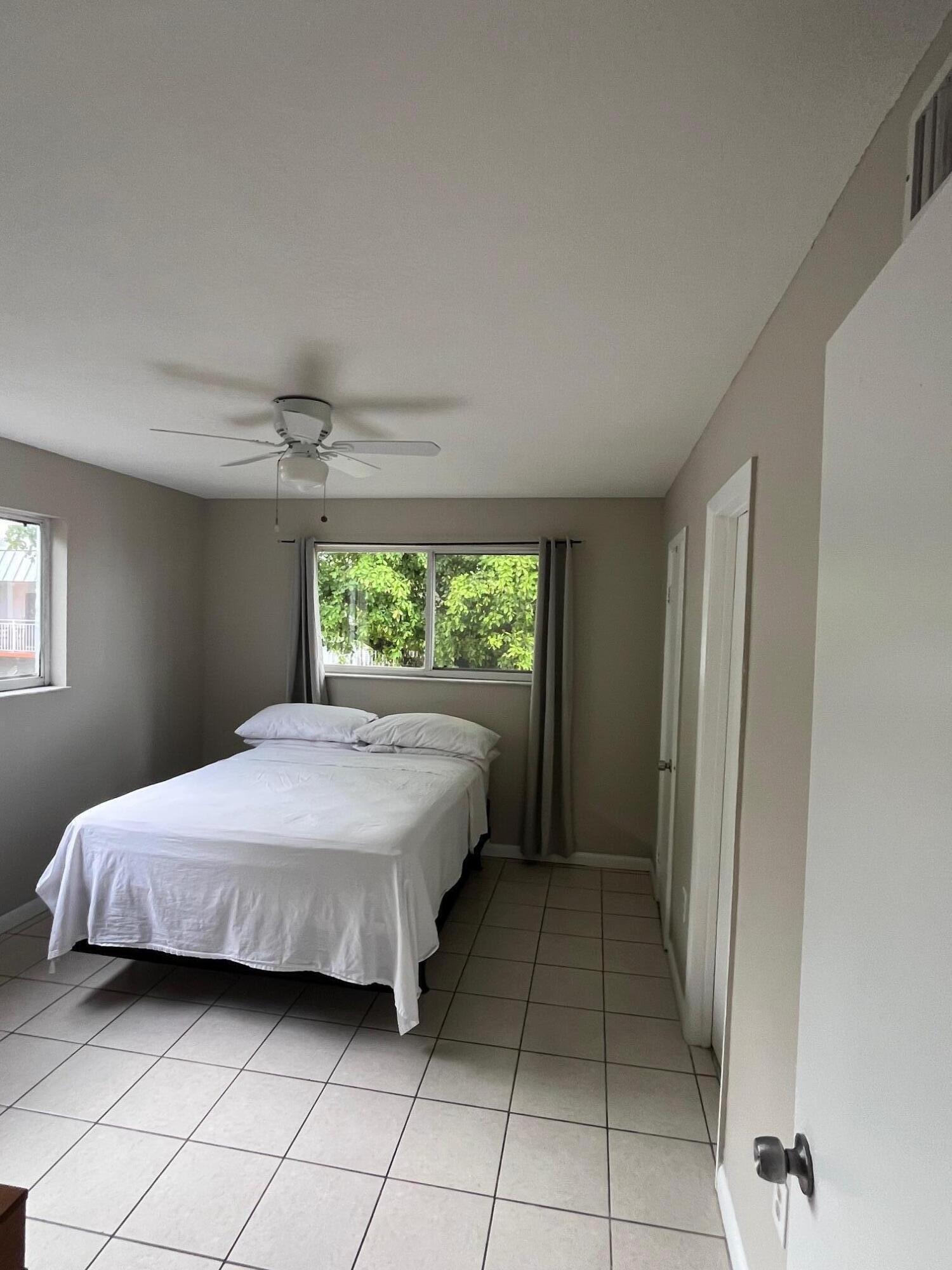 11307 Southwest 200th Street, Unit 313B Miami, FL 33157 - Photo 4 of 8 a bedroom with a bed and a window