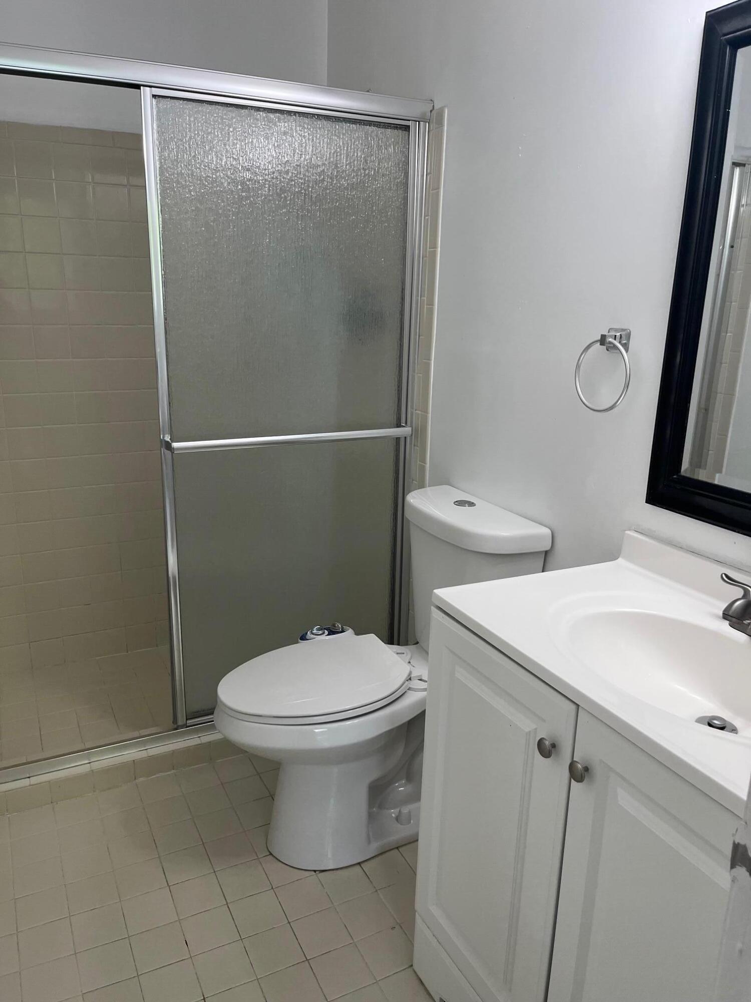 11307 Southwest 200th Street, Unit 313B Miami, FL 33157 - Photo 6 of 8 a white toilet sitting next to a bathroom sink