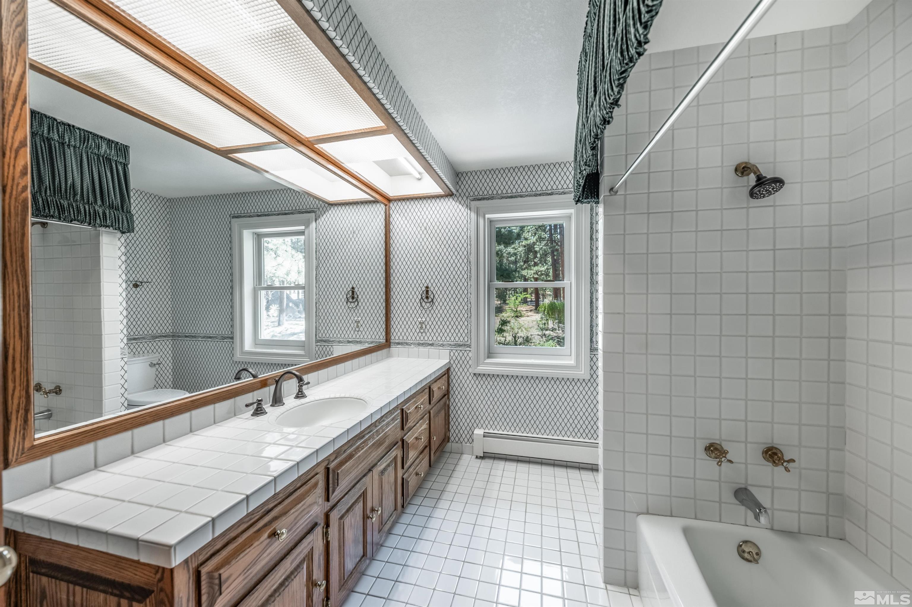 7250 Franktown Road Washoe Valley, NV 89704 - Photo 27 of 40 a bathroom with a granite countertop sink and a bathtub