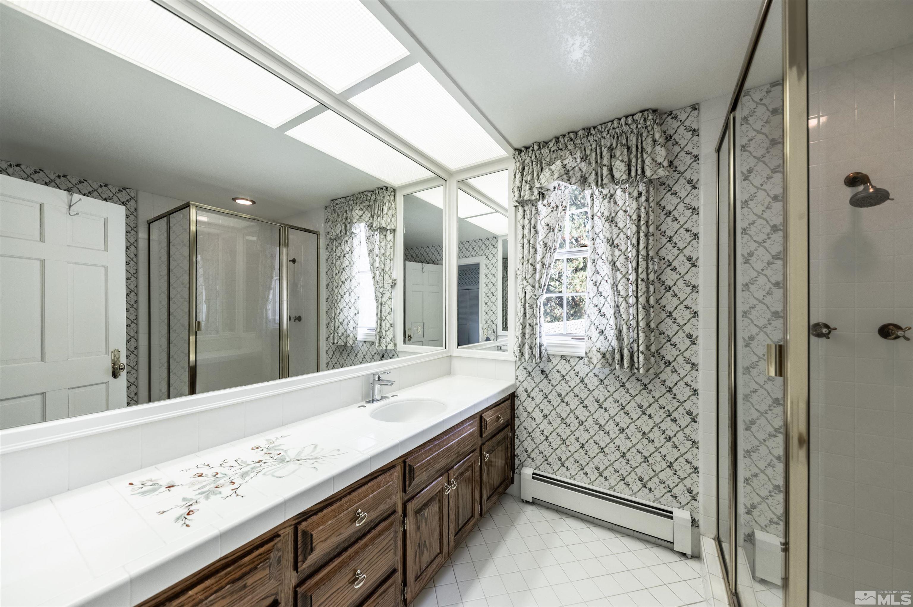 7250 Franktown Road Washoe Valley, NV 89704 - Photo 29 of 40 a bathroom with a double vanity sink mirror and shower