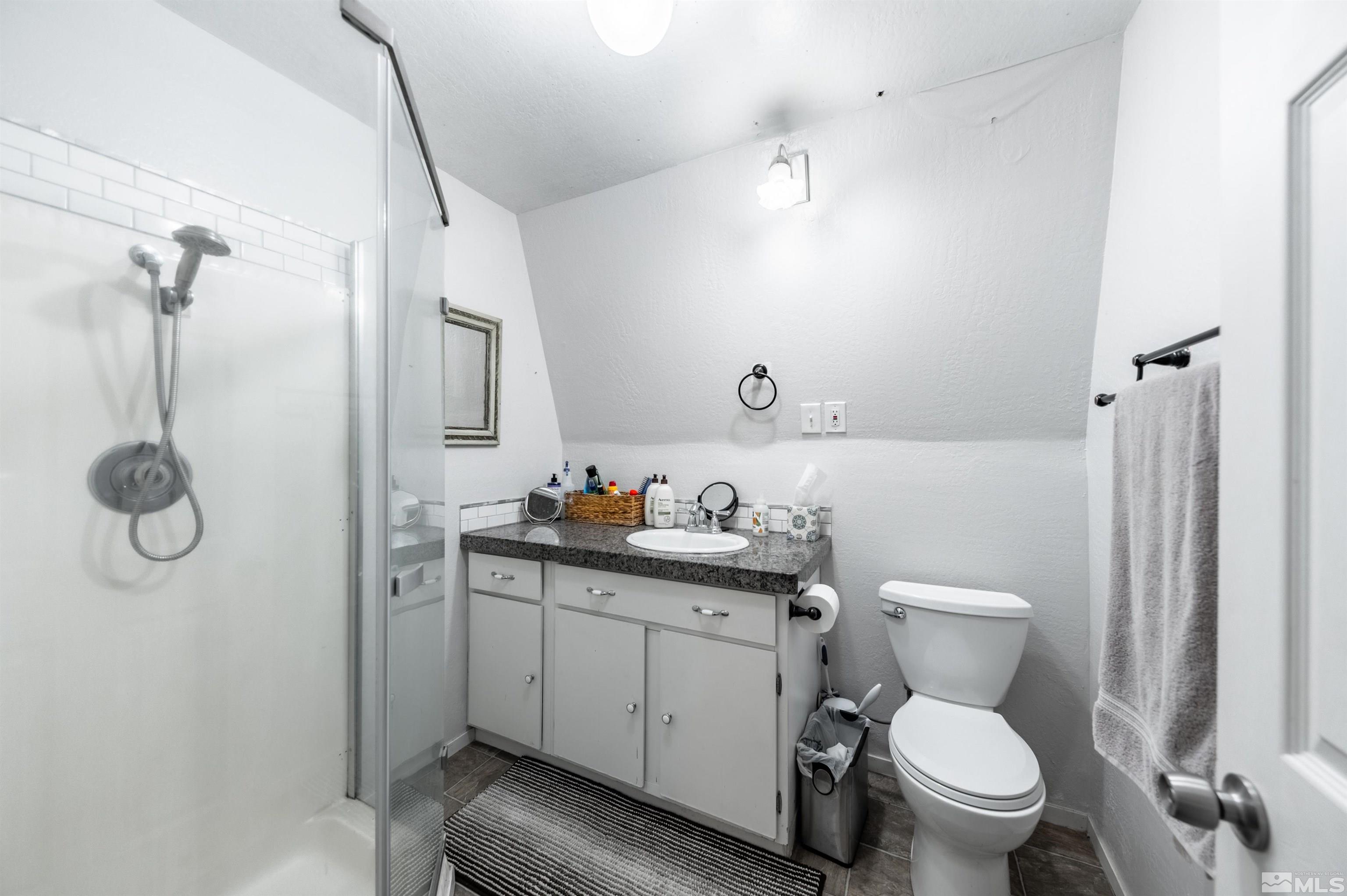 7250 Franktown Road Washoe Valley, NV 89704 - Photo 38 of 40 a bathroom with a toilet sink vanity granite and shower