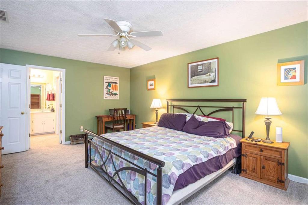 3838 Hunting Ridge Drive Southwest Lilburn, GA 30047 - Photo 28 of 56 a bedroom with a bed and a chandelier