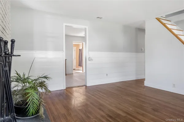 a view of a hallway with wooden floor and a potted plant