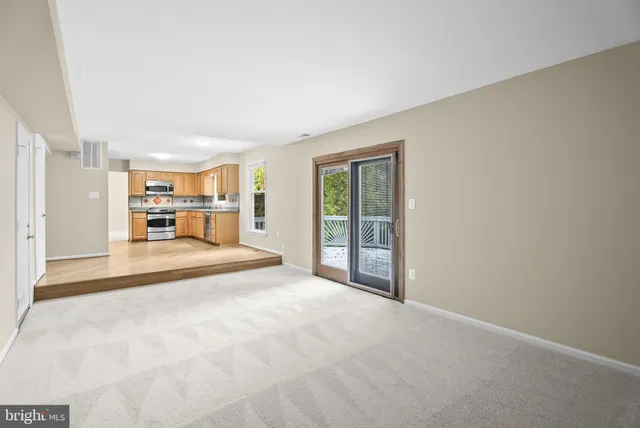 a view of kitchen with granite countertop cabinets and refrigerator