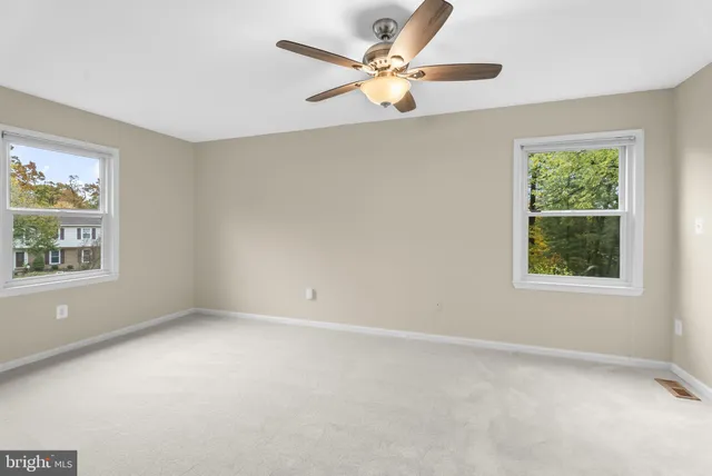 an empty room with a window and a fan