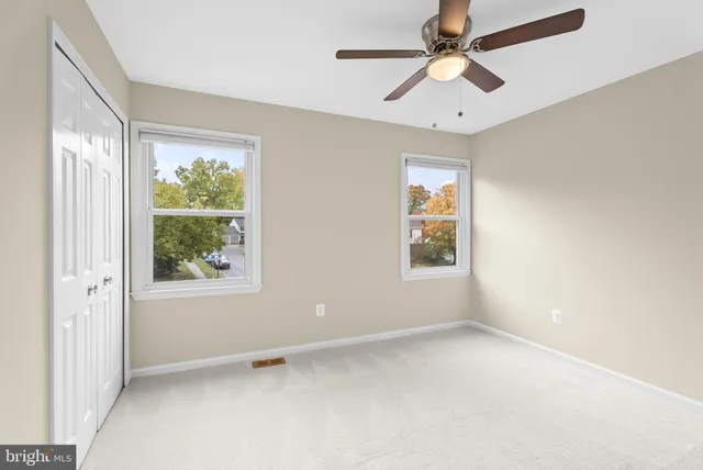 an empty room with a window and a fan