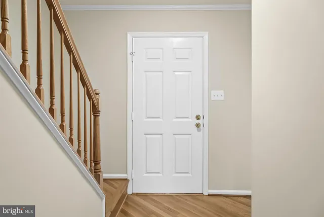a view of a hallway with wooden floor and entryway