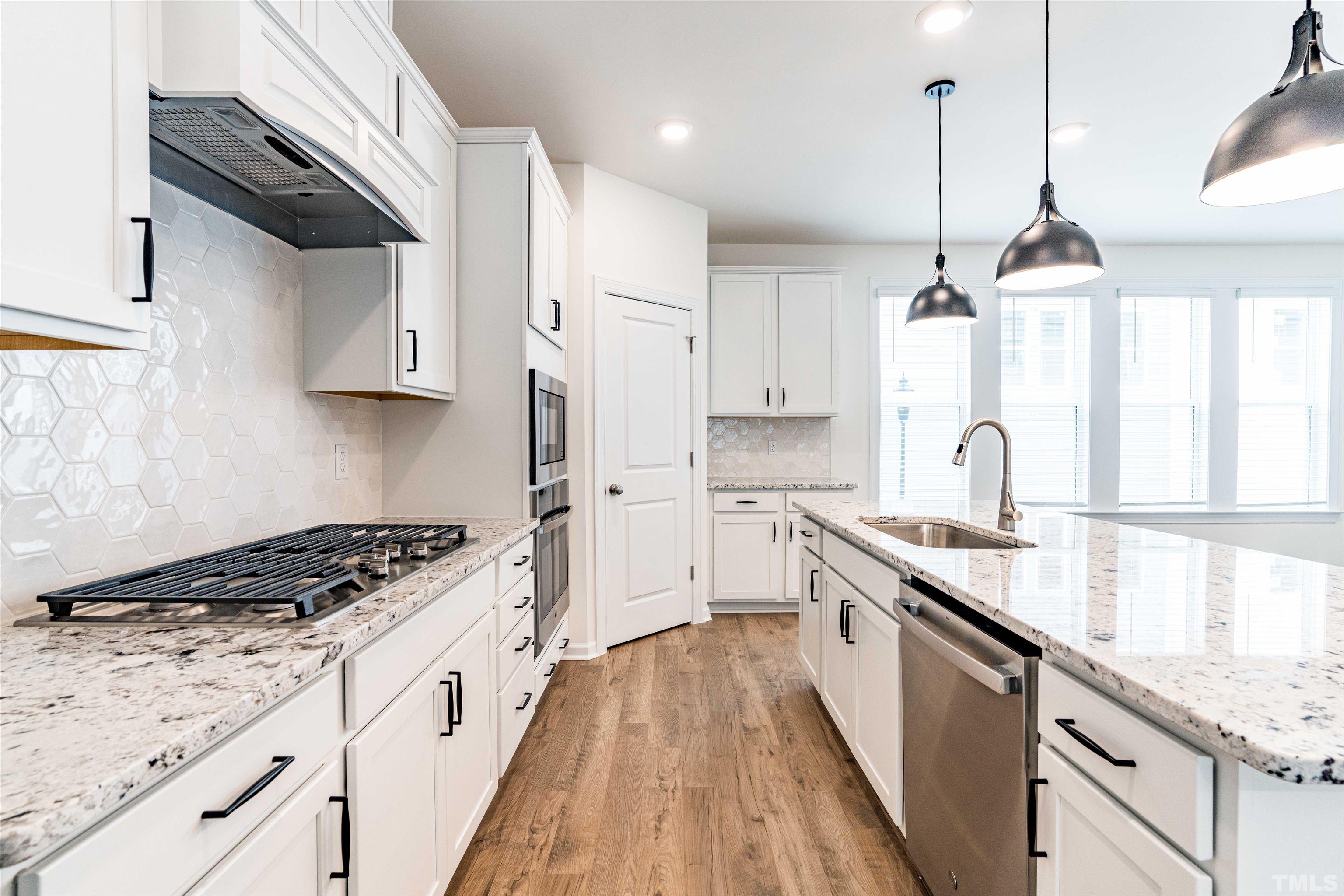 6936 Leesville Road Raleigh, NC 27613 - Photo 11 of 32 a kitchen with granite countertop a sink stove and cabinets