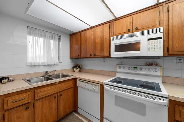 a kitchen with stainless steel appliances a refrigerator sink and microwave