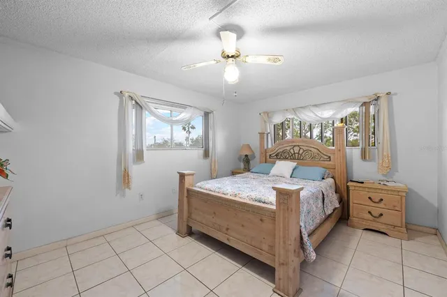 a bedroom with a large bed and a flat tv screen on dresser