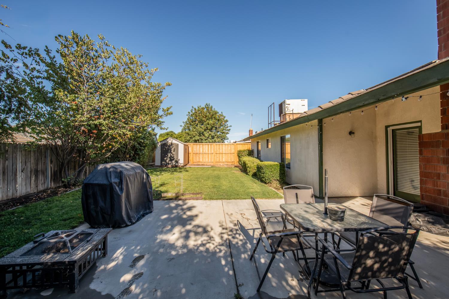 101 Cantebury Drive Lemoore, CA 93245 - Photo 5 of 16 a backyard of a house with yard and outdoor seating