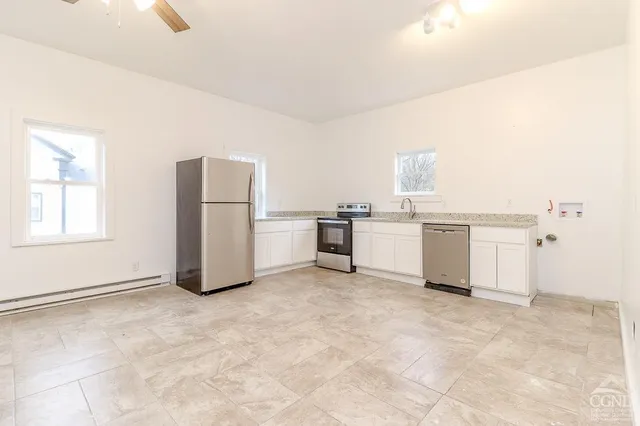 a view of kitchen with stainless steel appliances cabinets and wooden floor
