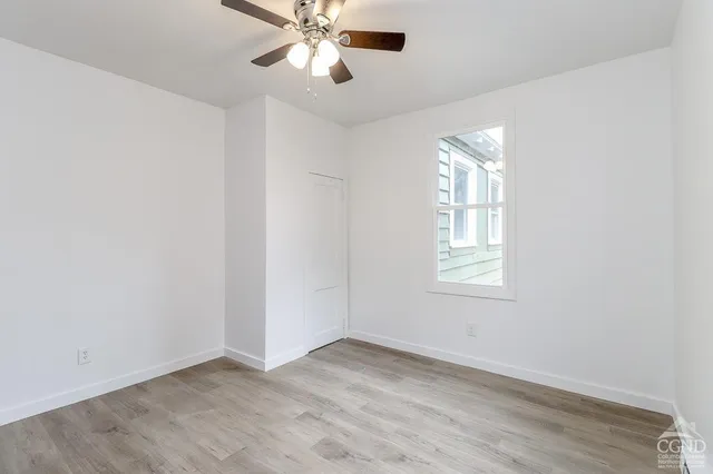 an empty room with windows and fan